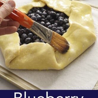 A blueberry galette getting brushed with an egg wash.
