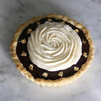 Chocolate Tart with gold flecks on marble.