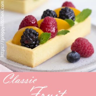 a photo of a rectangular fruit tart with a few sprigs of mint.
