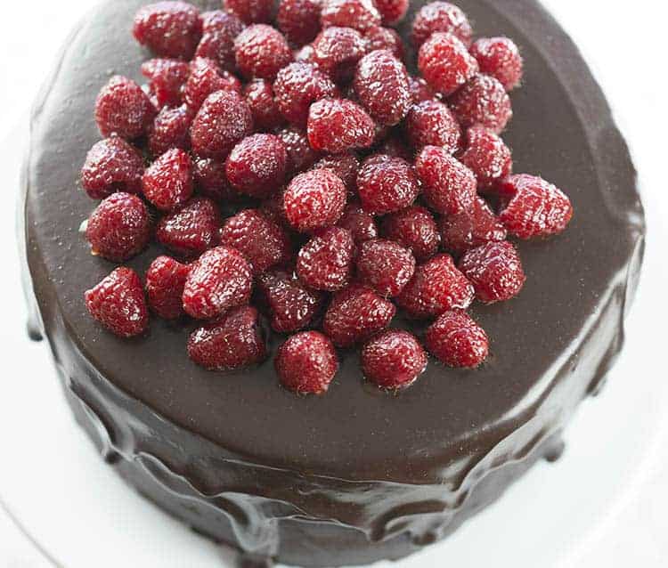 A large chocolate cake covered in raspberries