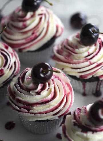 Chocolate cupcakes filled with a cherry, topped with buttercream and cherry reduction.