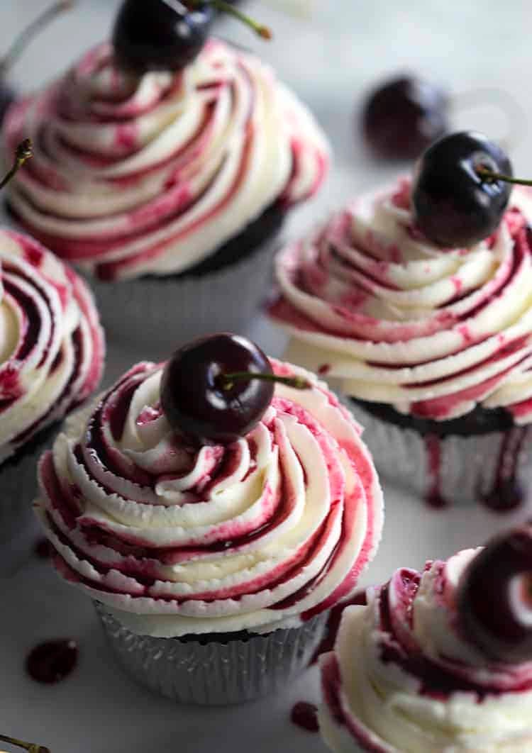 Chocolate cupcakes filled with a cherry, topped with buttercream and cherry reduction.