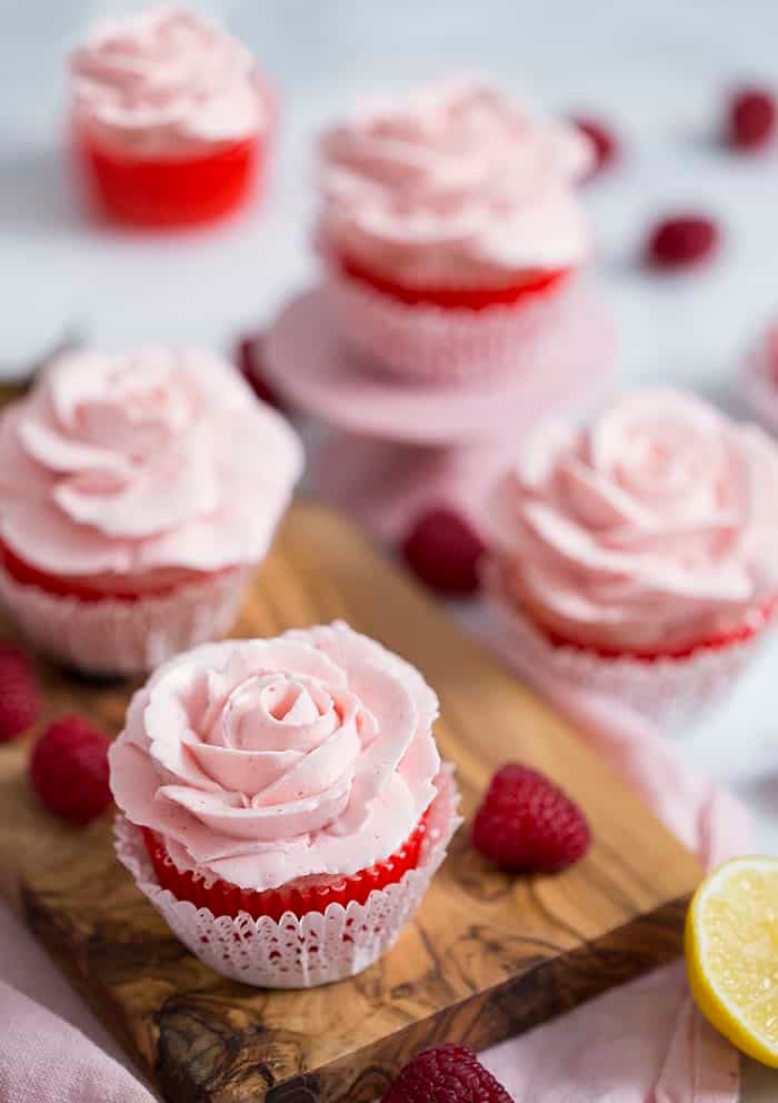 A photo showing a group of cupcakes topped with pink buttercream roses.