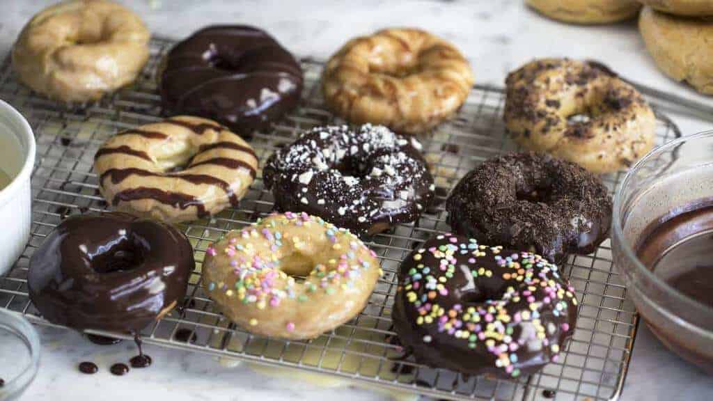 A photo of Chocolate Eclair Donuts on a cooling rack.
