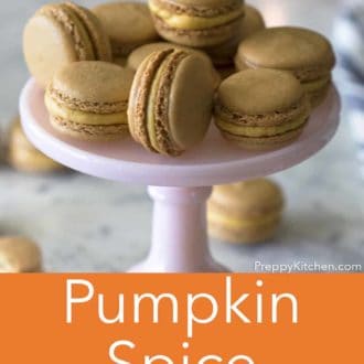 pumpkin spice macarons stacked on a pink cake stand