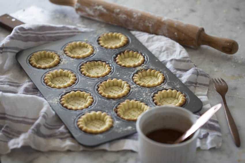 A photo of baked tart shells ready to be filled.