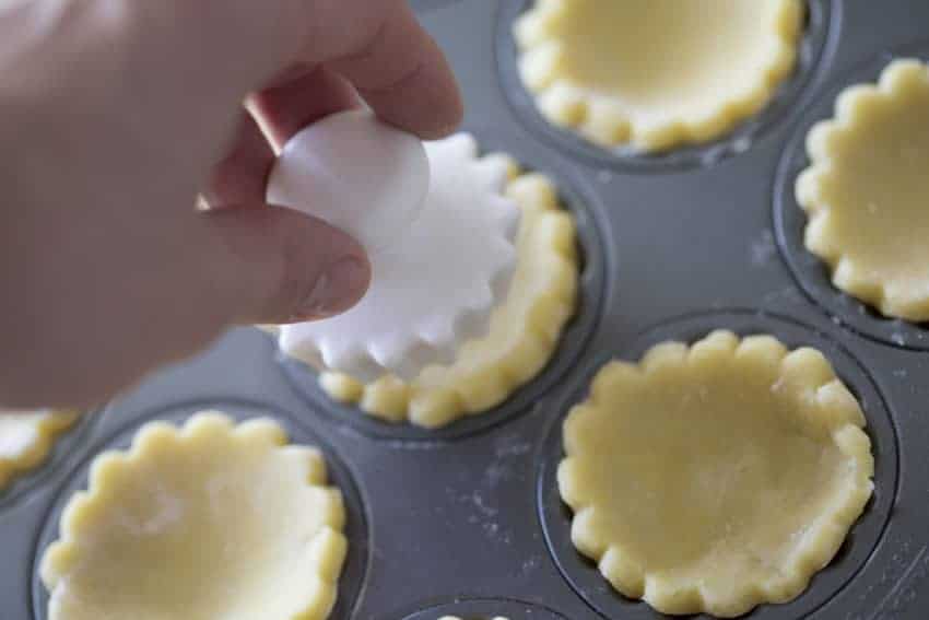 Plastic form pressing into pastry crust to push it down.