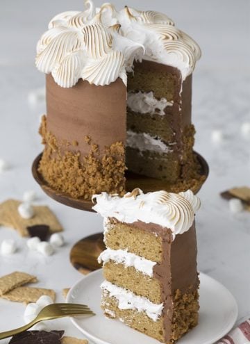 A photo of a s'mores cake with a piece on a plate ready to be served.