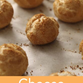 Some cheese puffs cooling on a baking sheet.