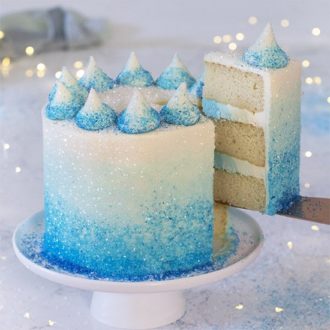 A photo of a blue ombre cake with a piece coming out.