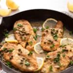 A cast iron skillet with chicken piccata.