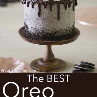 three layer oreo cake with chocolate ganache drip on a cake stand
