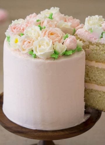 A photo of a cake with buttercream roses on top.