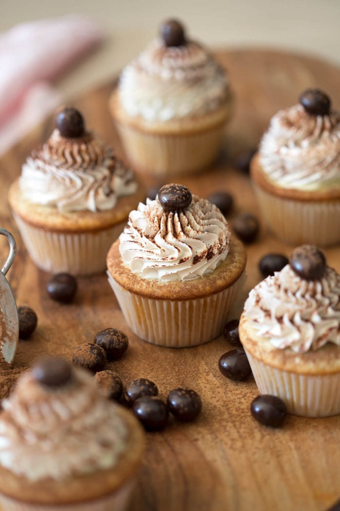 A photo of tiramisu cupcakes on a wooden board 