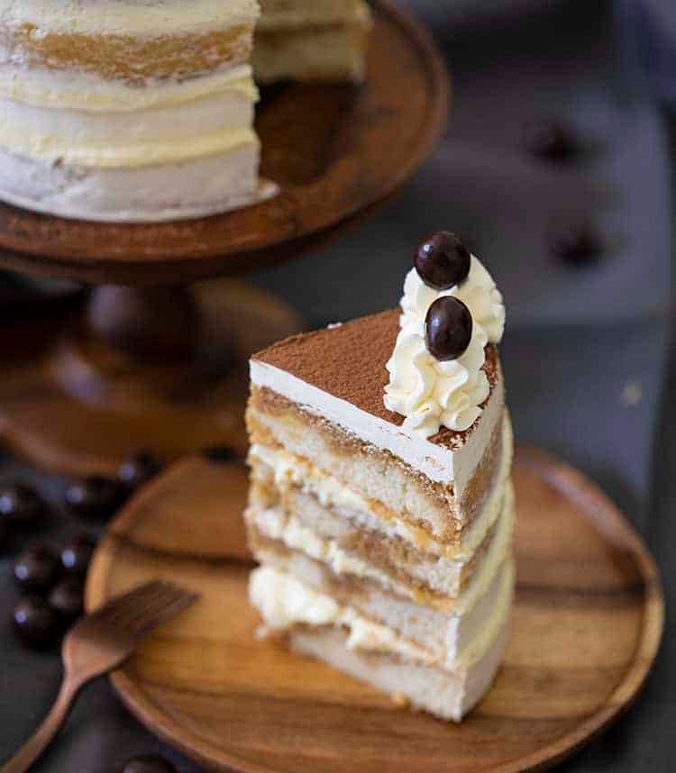 A piece of tiramisu cake on a wooden plate