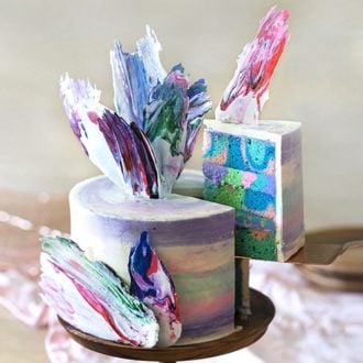 A peacock cake with a slice being lifted from the cake.