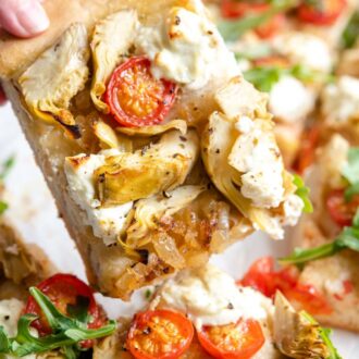 A slice of artichoke pizza lifted up.
