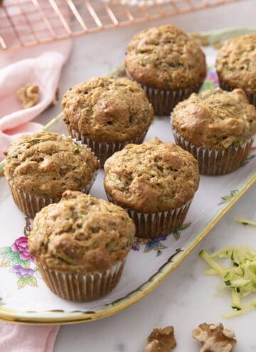 Multiple zucchini muffins on a serving tray.