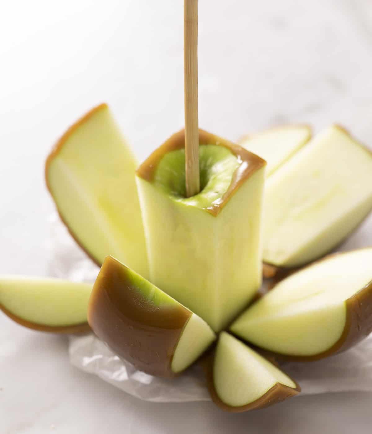 A closeup of a caramel apple that has been cut into sections
