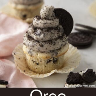 Pinterest graphic of an Oreo cupcake with Oreo frosting on an opened wrapper dusted with crushed Oreo cookies.