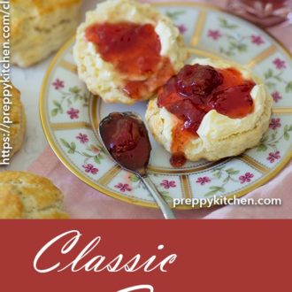 A clipping of classic english style scones on a plate with butter and jam.