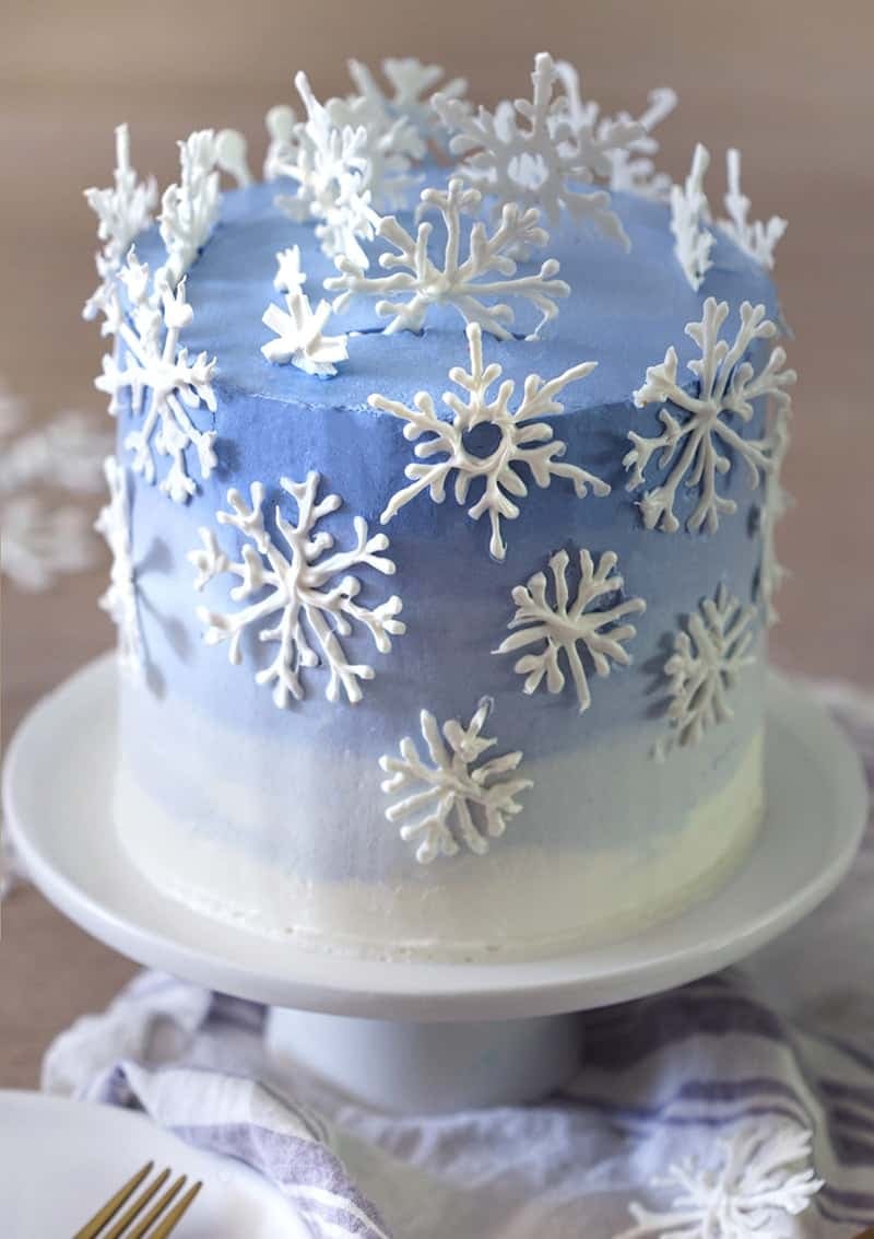 A photo of a blue and white ombre cake with snowflakes on top.