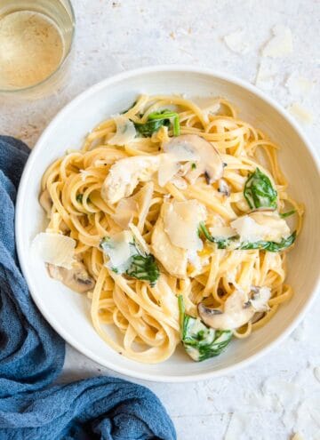 An overhead shot of artichoke pasta in a bowl with mushrooms and spinach