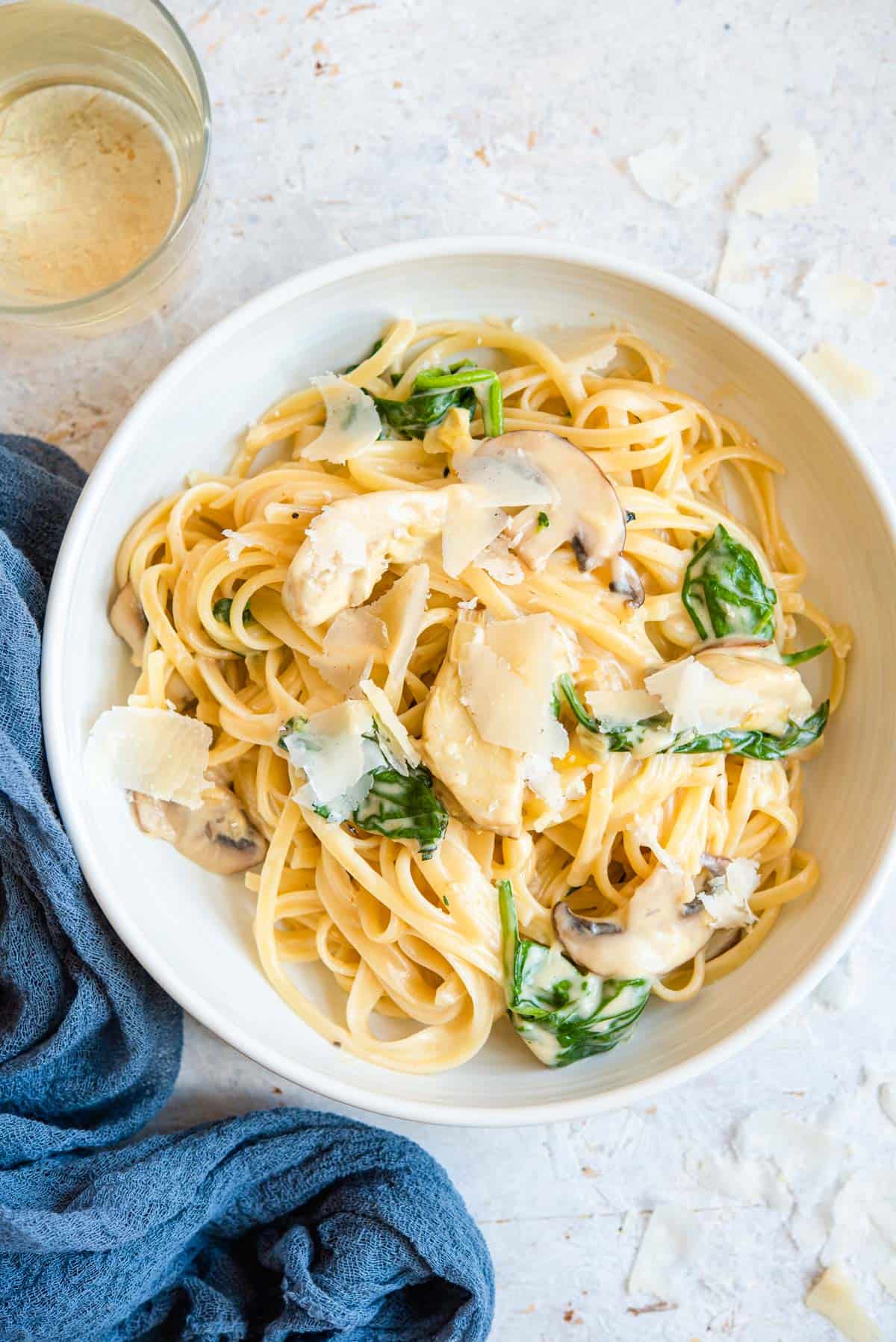 An overhead shot of artichoke pasta in a bowl with mushrooms and spinach