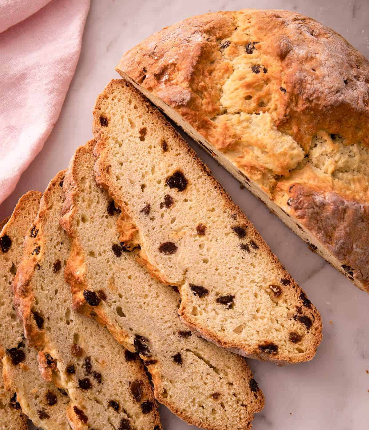 Overhead view of a loaf of Irish soda bread cut into slices.
