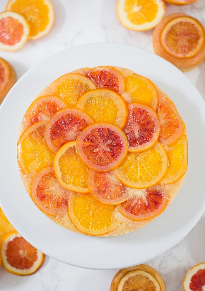 a top down photo of an orange upside down cake on a white cake strand