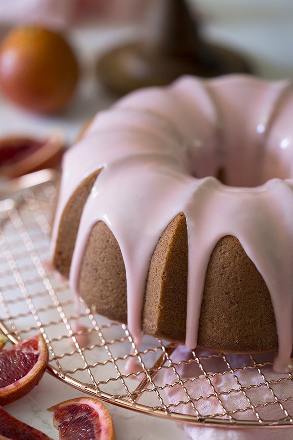 A close-up photo showing a blood orange bundt cake with a soft pink glaze.