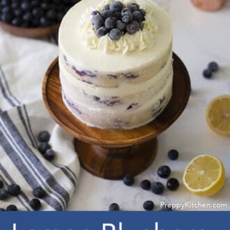 three layered lemon blueberry cake with white frosting on a stand