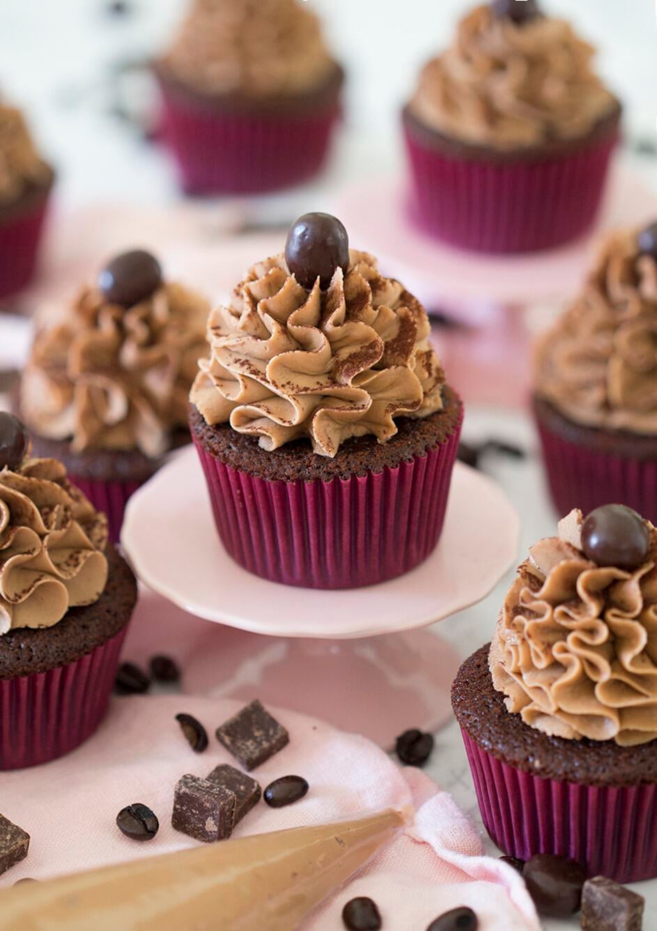 Mocha Cupcakes with chocolate and coffee beans around them.