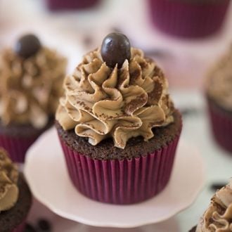A mocha cupcake on a mini cake plate.
