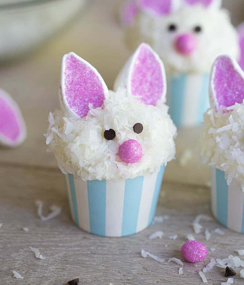 Easter bunny cupcakes on a wooden table.