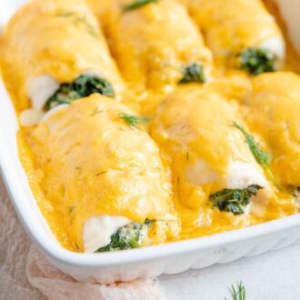 Close up of fillet of sole in a baking dish with cheese sauce.
