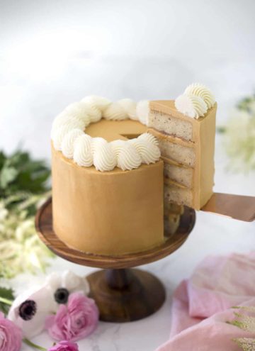 A photo of a piece being removed from a Dulce De Leche Cake.