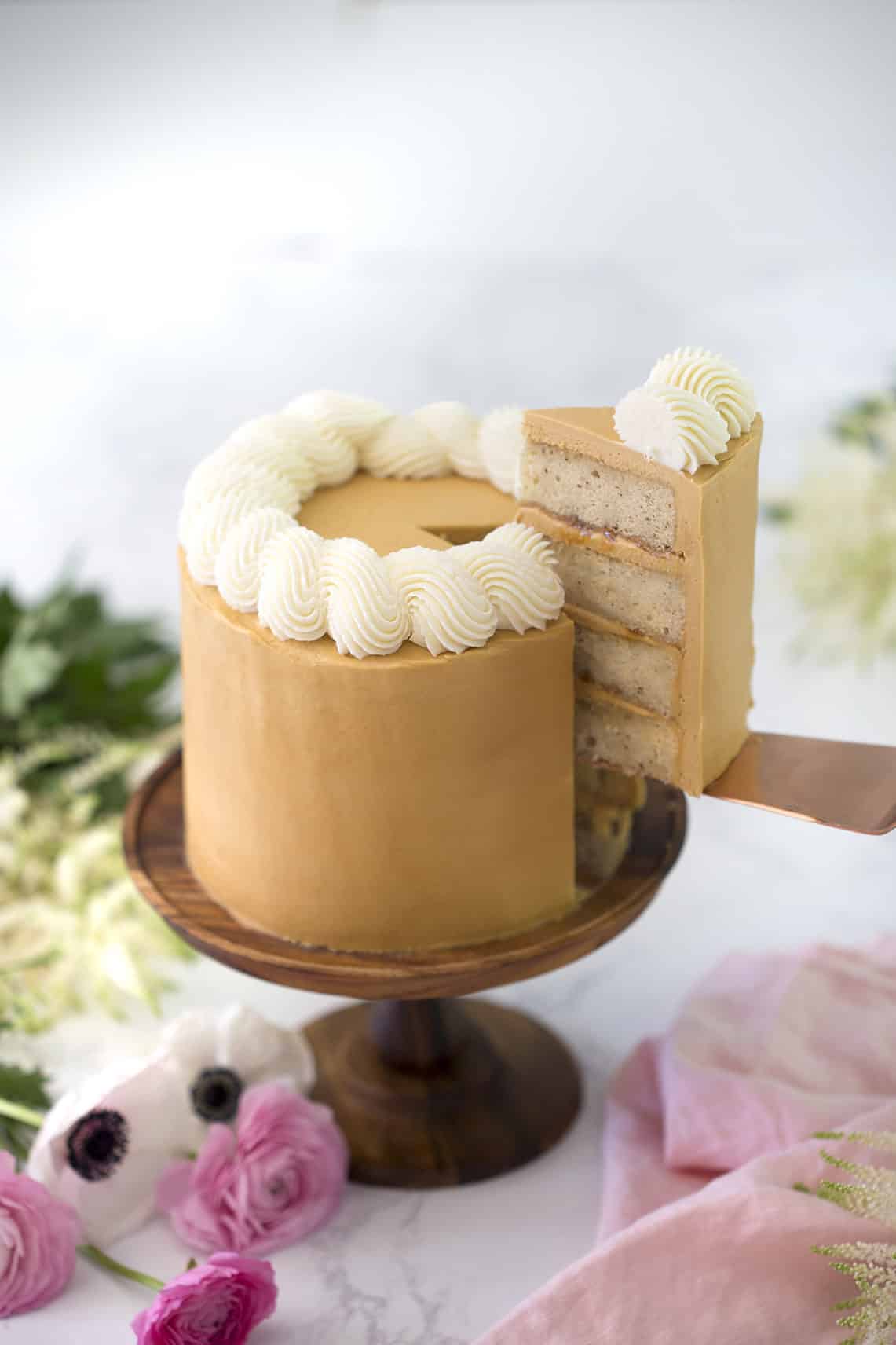 A photo of a piece being removed from a Dulce De Leche Cake.