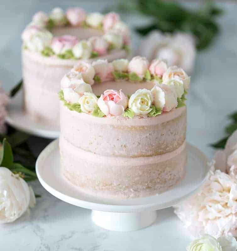 Photo of two cakes on white cake stands.