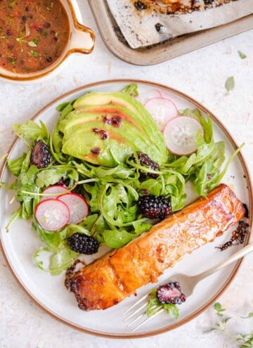 An overhead shot of glazed salmon on a plate with salad