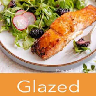 A side shot of glazed salmon and salad with glazed salmon written in text underneath