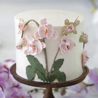 photo of a brown butter cake covered in buttercream orchids