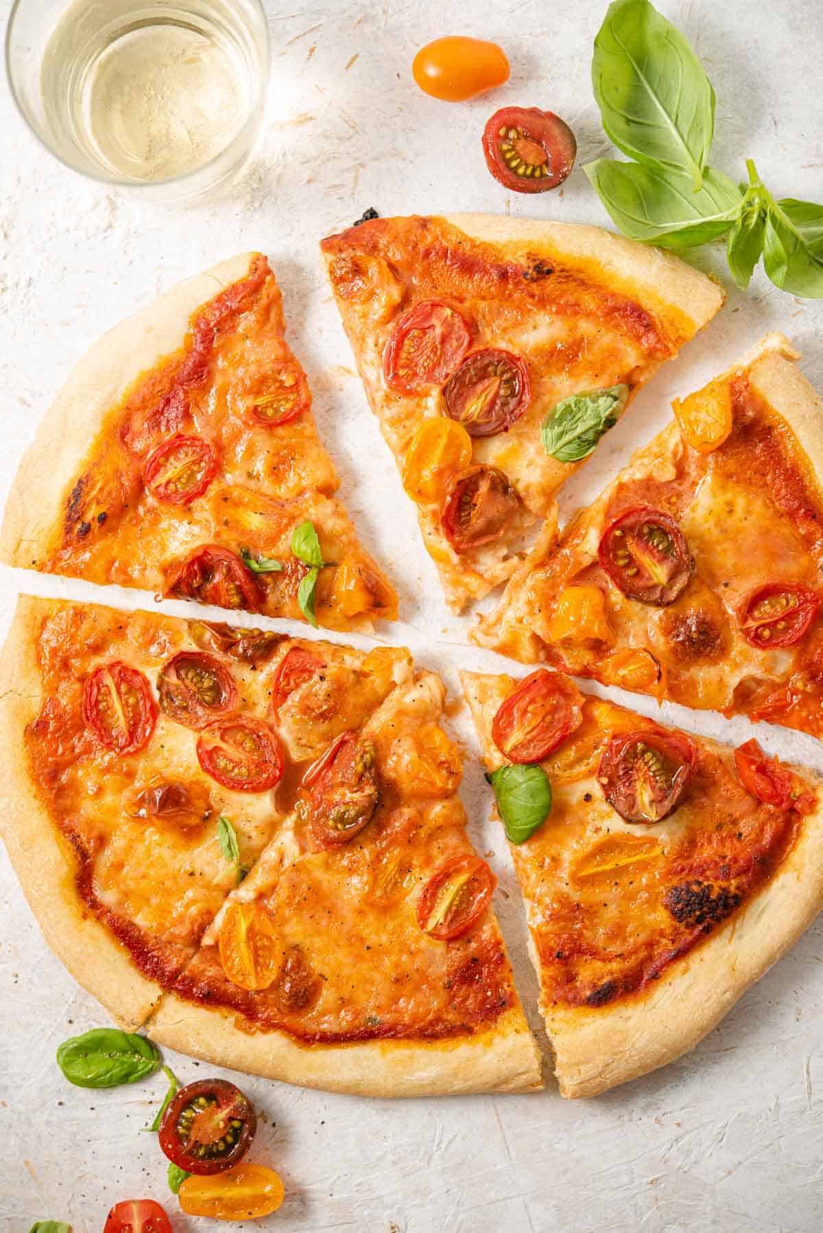 An overhead shot of a tomato pizza cut into slices