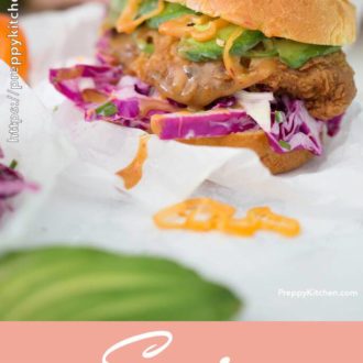 A spicy chicken sandwich on a brioche bun with rose wine