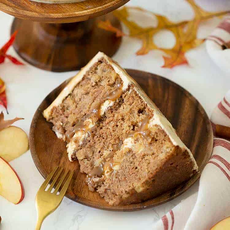 A piece of three layer apple spice cake with caramel and brown butter frosting.