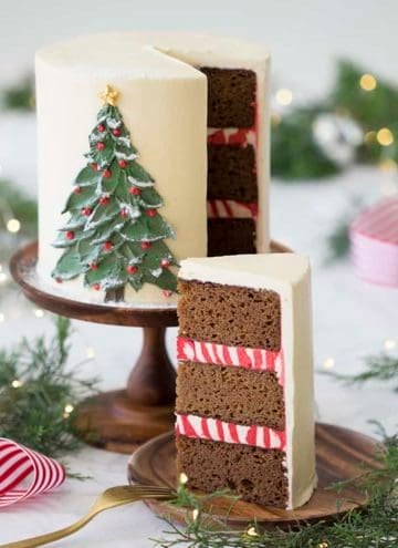 A photo of a gingerbread cake with a painted Christmas tree made from butter cream on the front.