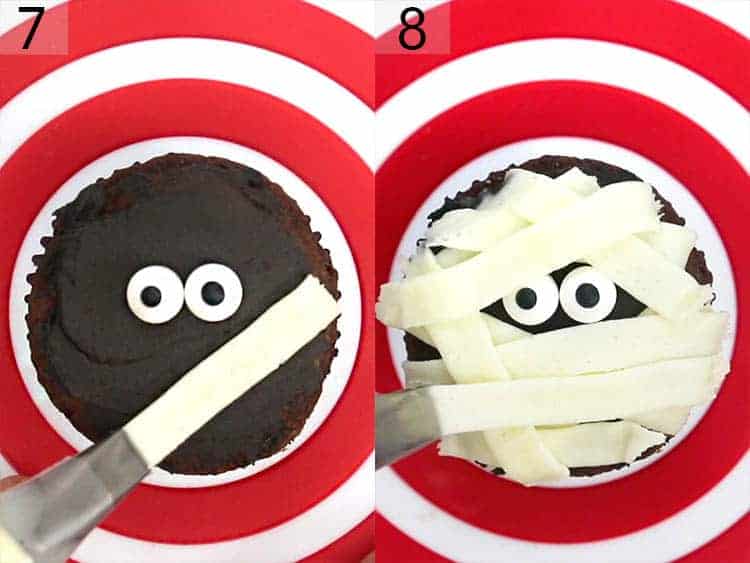 A mummy cupcake getting decorated.