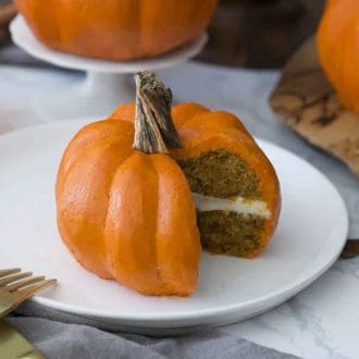A pumpkin Bundt cake that looks just like a pumpkin with a piece cut out showing the cake inside