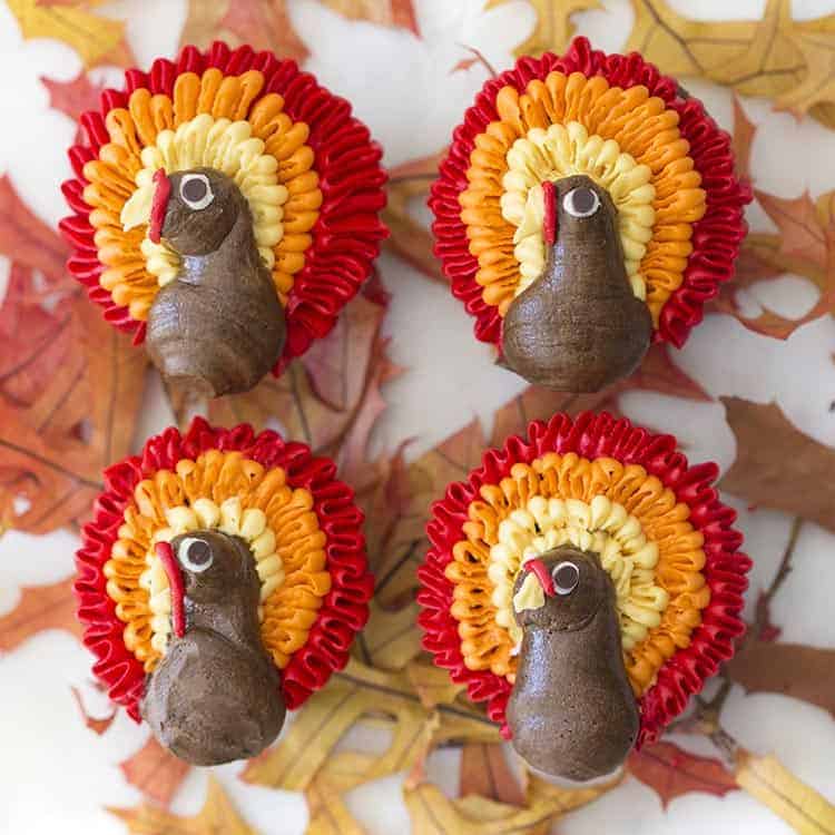 Four chocolate cupcakes topped with buttercream turkeys