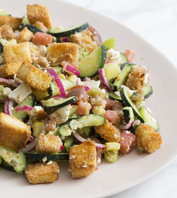 A photo of a panzanella salad on a serving plate.